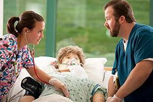 Two Training Center student working with Mannikin in hosptial bed