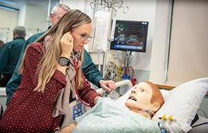 Female student with stethoscope on Mannikin